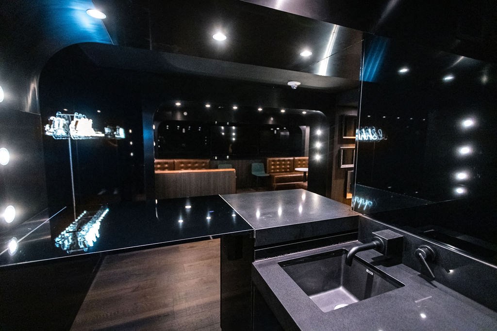 a black bathroom with a sink and a large mirror