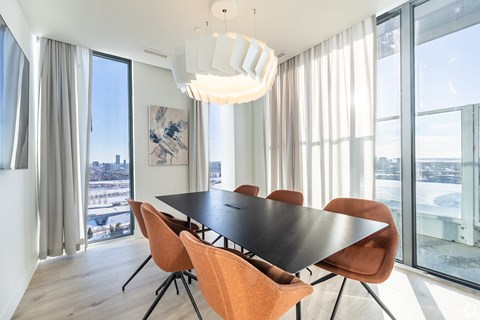 A modern dining room with a large table and chairs.