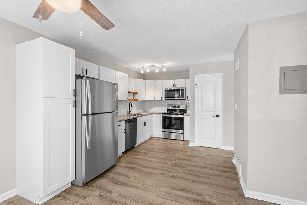 a renovated kitchen with stainless steel appliances and white cabinets