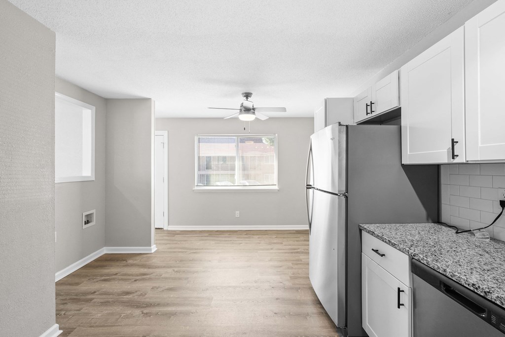 an empty kitchen with stainless steel appliances and a window