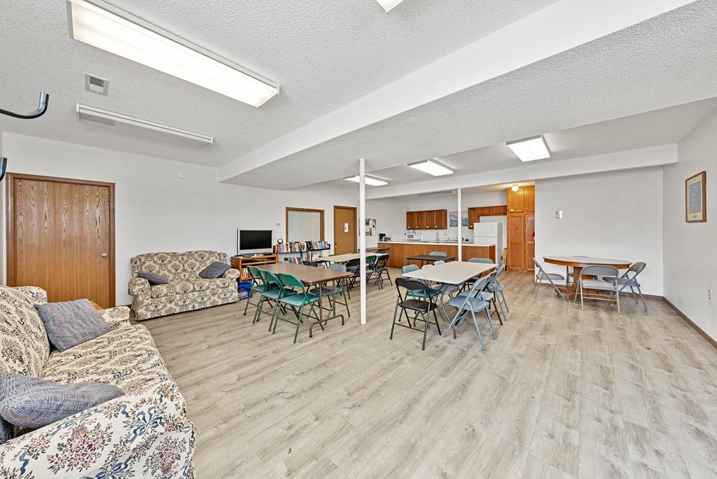 a dining room with tables and chairs and a living room