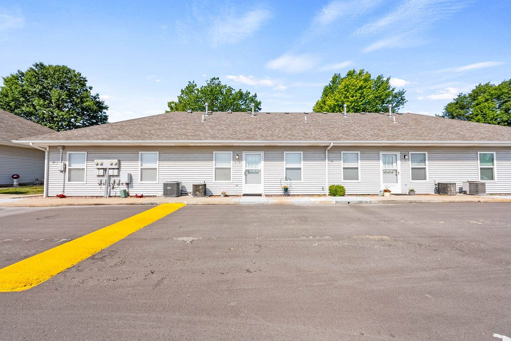 an empty parking lot in front of a white building