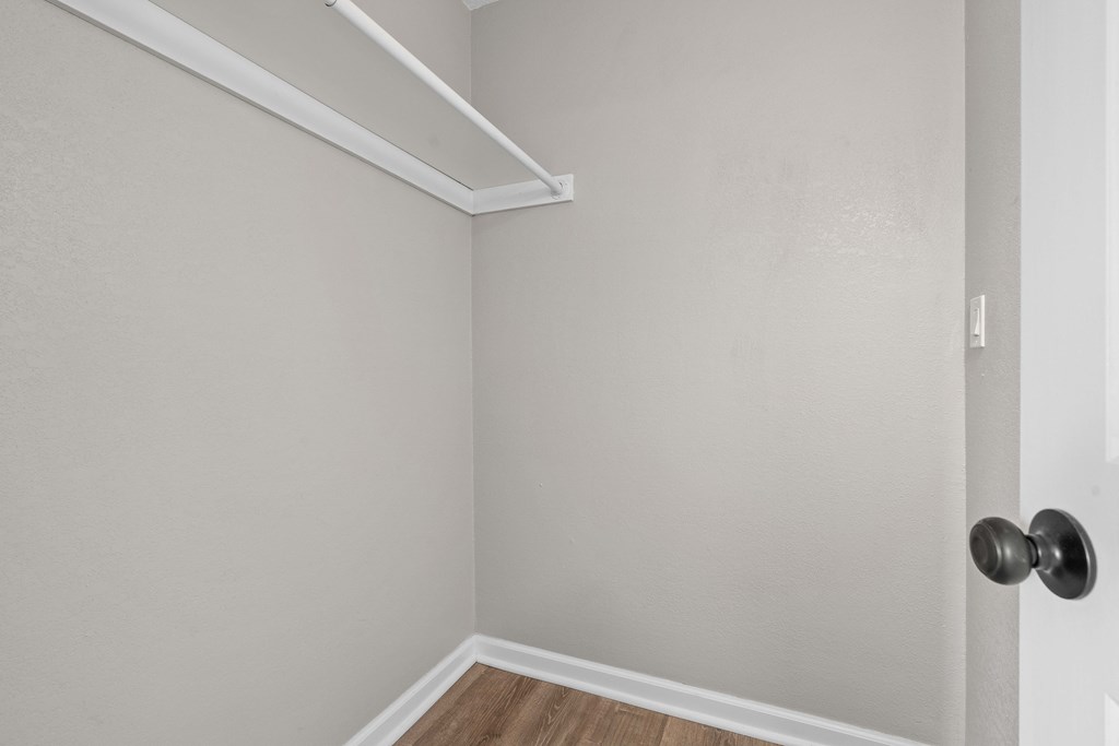 an empty room with white walls and wood flooring and a door