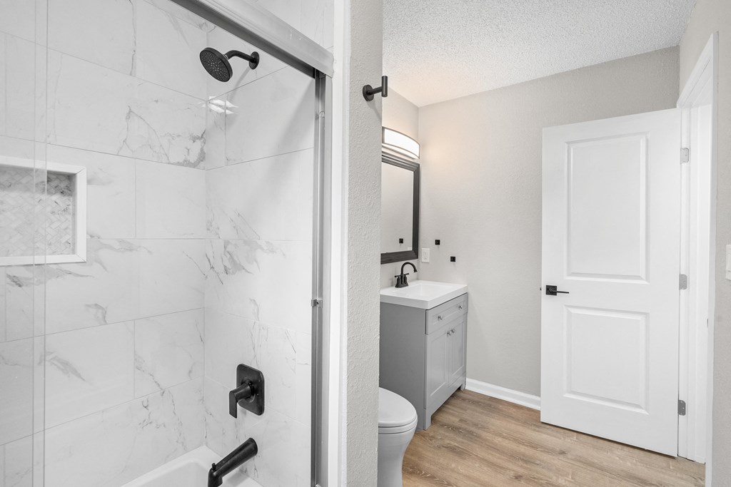 a bathroom with a shower and a sink and a toilet