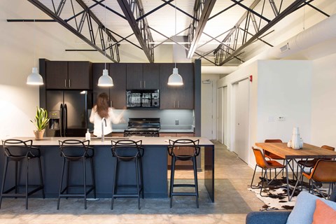 a kitchen and dining area in a modern office space with high ceilings