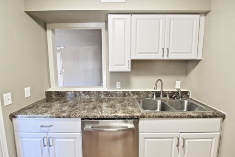 a kitchen with white cabinets and granite counter top and a sink