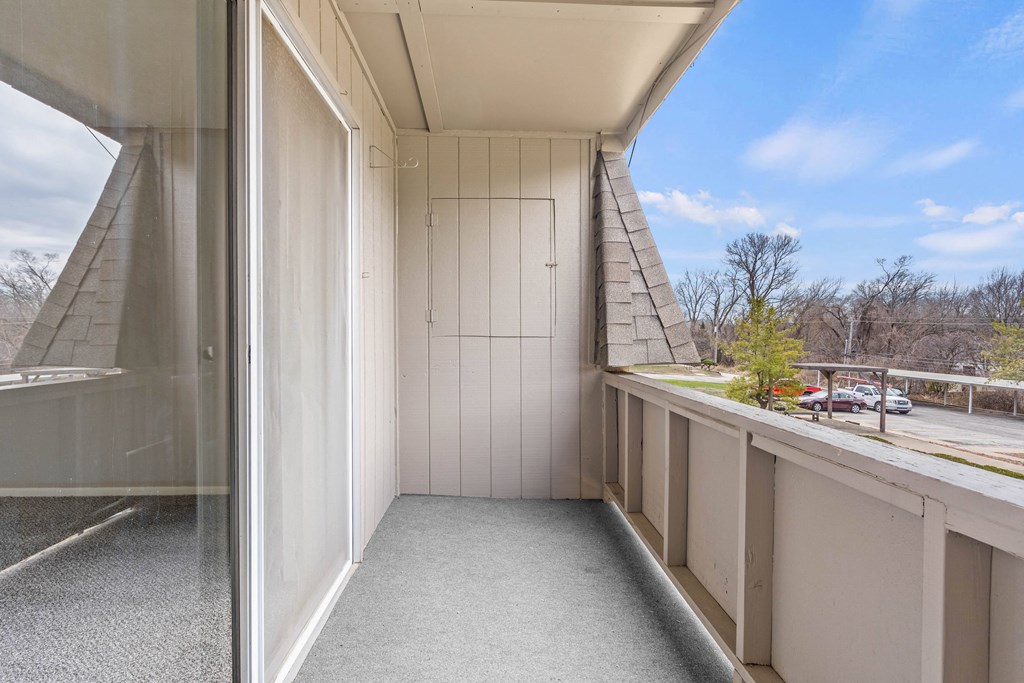 a balcony with a door and a blue sky in the background
