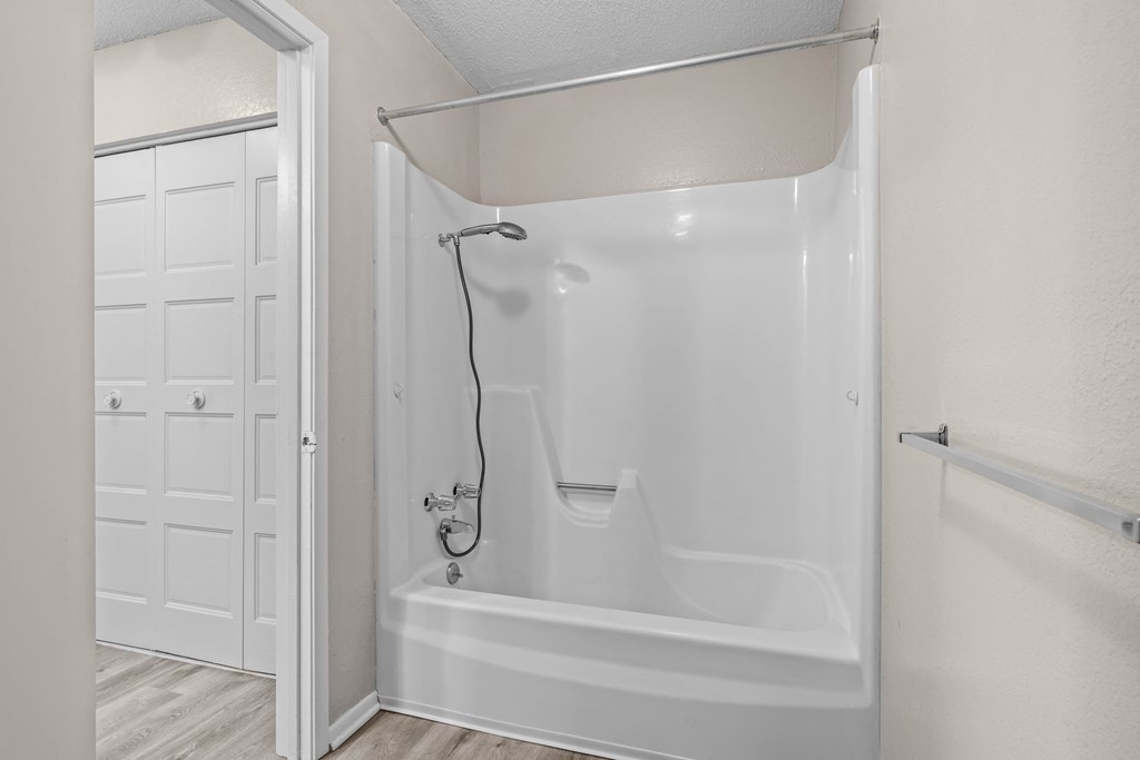 a bathroom with a white bathtub and a white door