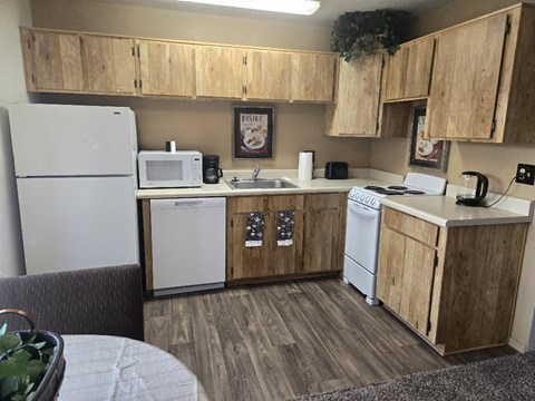 A kitchen with wooden cabinets and white appliances.