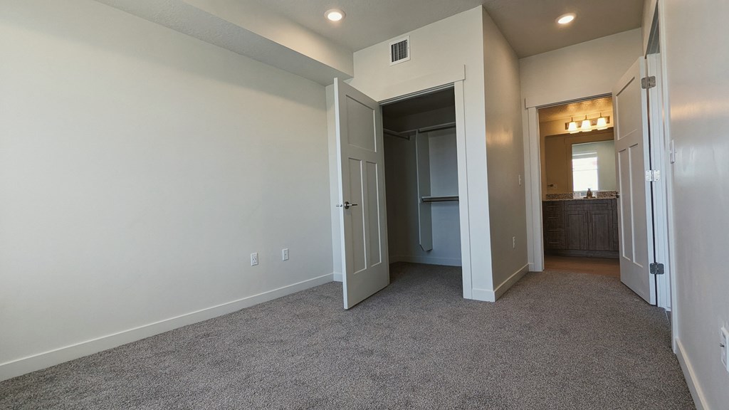 A bedroom with gray carpet and white walls
