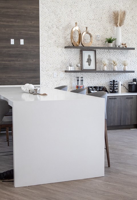 A kitchen with white countertops and a white island