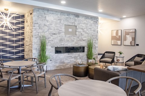 A common room with tables and chairs and a fireplace