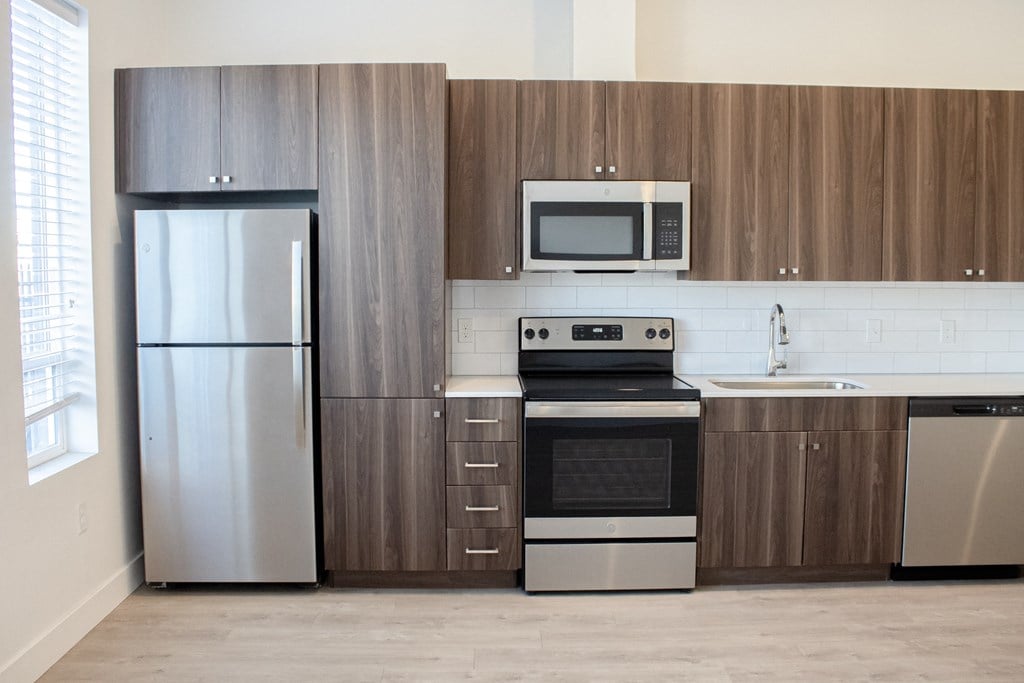 A kitchen with wooden cabinets and stainless steel appliances