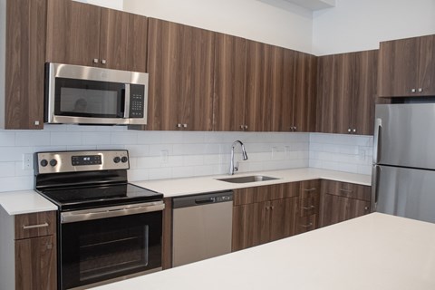 a kitchen with white countertops and wooden cabinets