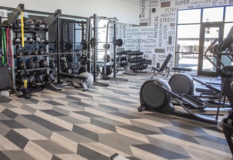 A fitness room with a checkered floor and weights