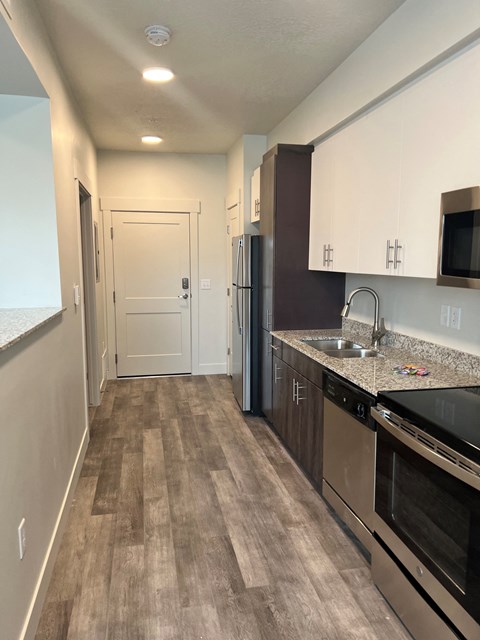 a kitchen with stainless steel appliances and a sink and a refrigerator