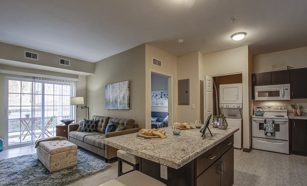 a kitchen and living room with a granite counter top