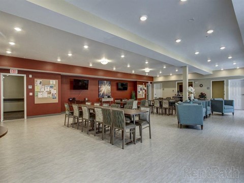 A spacious room with a dining table set up with chairs and a couch.
