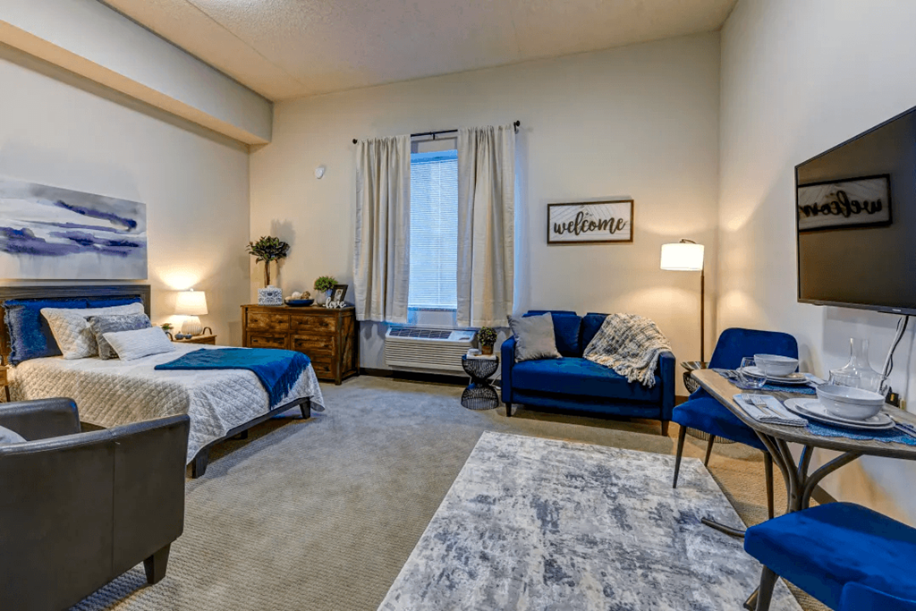 a bedroom with two beds and a living room with a tv