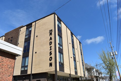 The Madison building has a beige facade with darker trim.