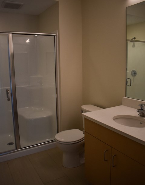 A bathroom with a toilet, sink, and shower.