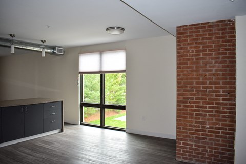 A room with a brick wall and a sliding glass door.