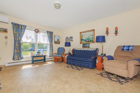a living room with a couch and a chair and a window