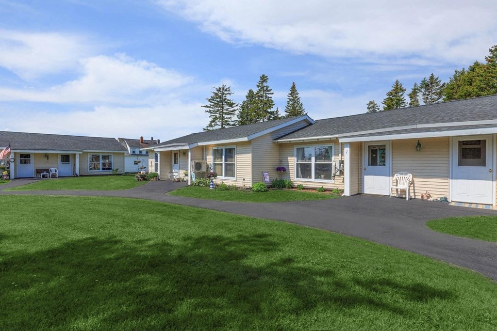 a group of houses with a grassy yard and a driveway