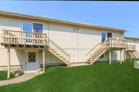 the back of a house with a staircase and a porch