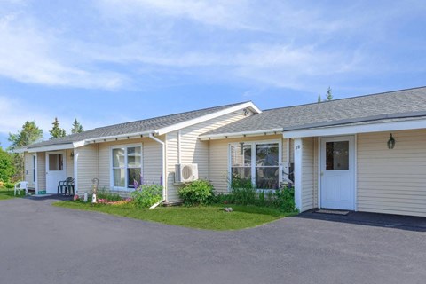 the front of a white house with a driveway