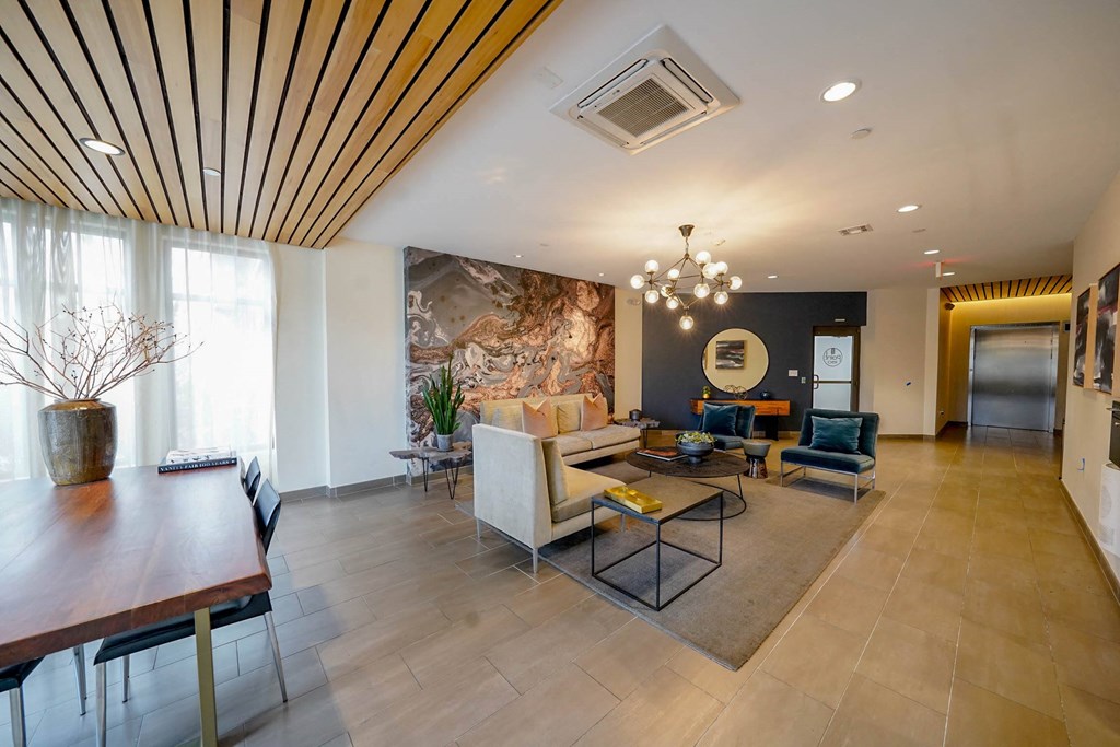 A modern living room with a wooden ceiling and a large painting on the wall.