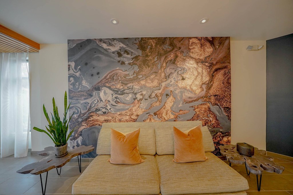 A bedroom with a large bed and a large painting on the wall.