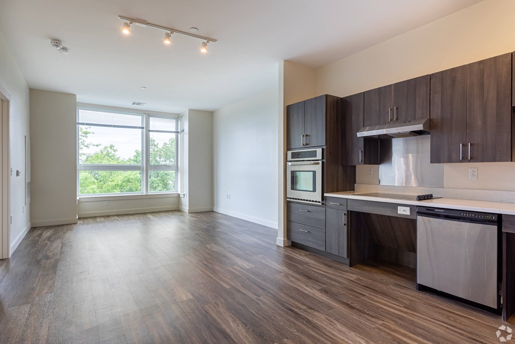 A kitchen with dark wood cabinets and a white countertop.