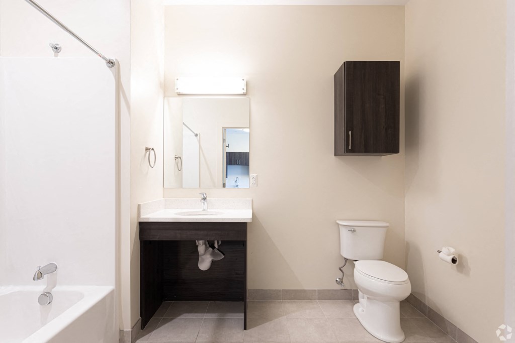 A white toilet sits next to a sink in a small bathroom.