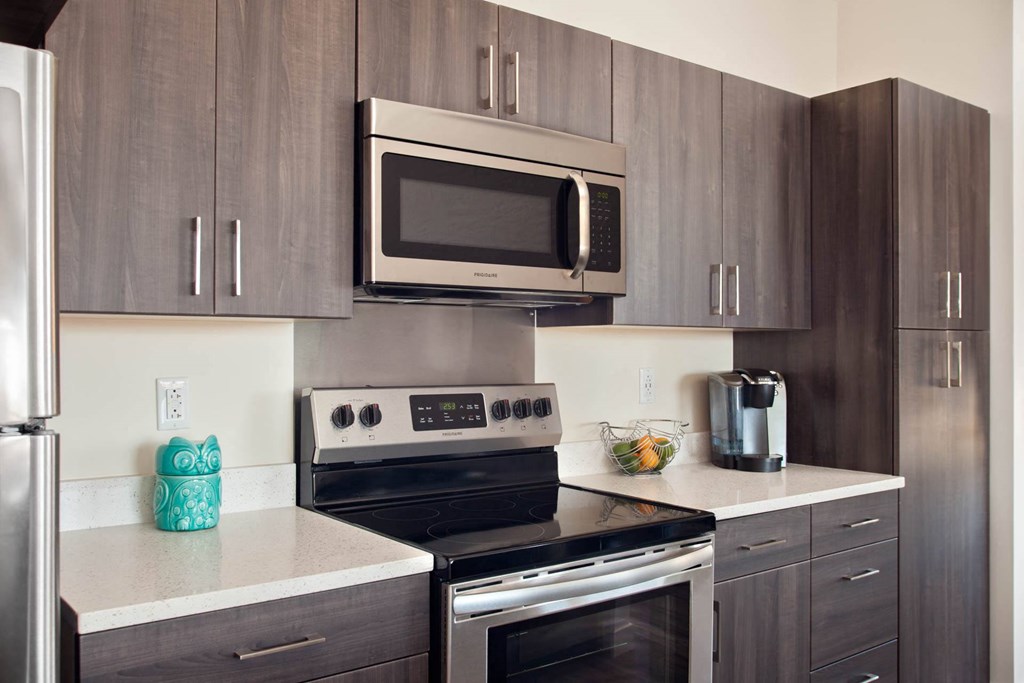 A kitchen with a stove top oven and microwave above it.