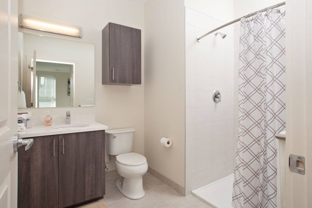 A bathroom with a toilet, sink, and shower.