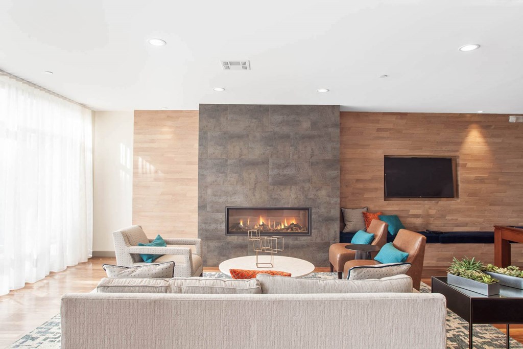 A modern living room with a fireplace and a flat screen TV mounted on the wall.