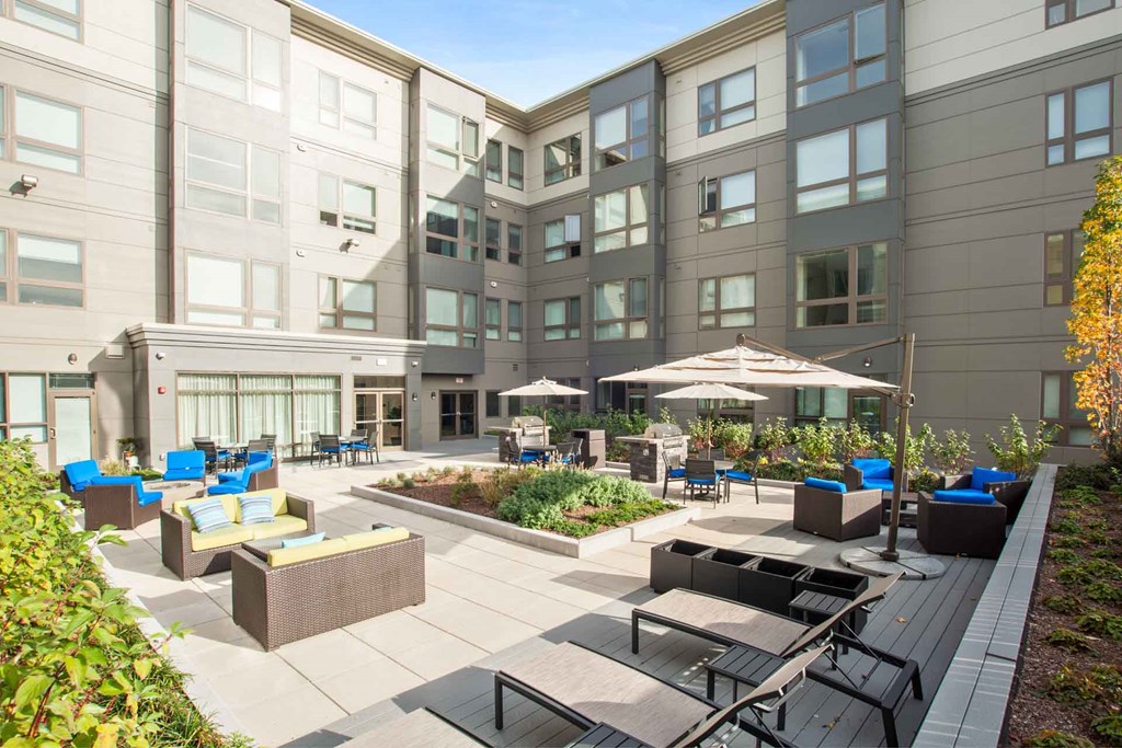 A sunny day at a modern apartment complex with a well-kept courtyard.