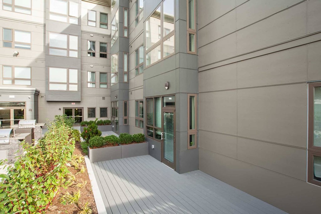 A modern building with a grey facade and a wooden deck.