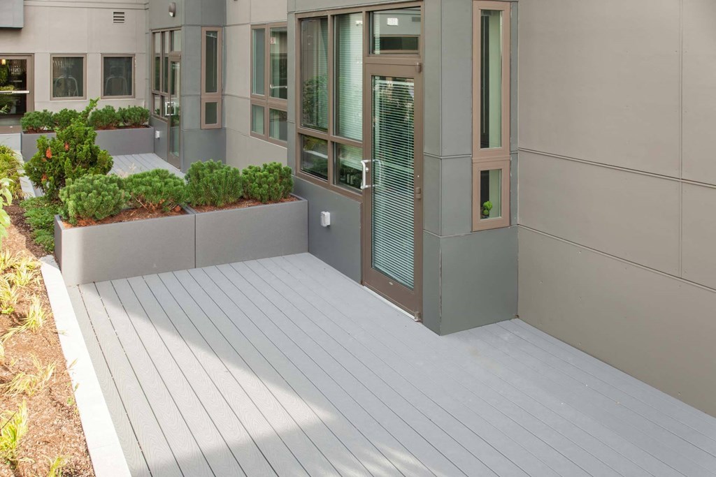 A modern building with a grey facade and a wooden deck.