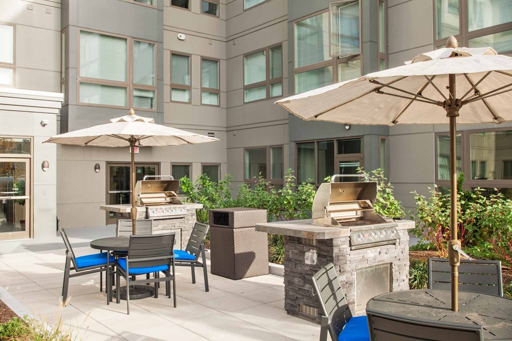 A patio with a table, chairs, and an umbrella.