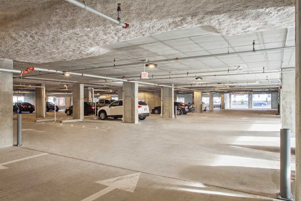 A parking garage with concrete pillars and a concrete ceiling.