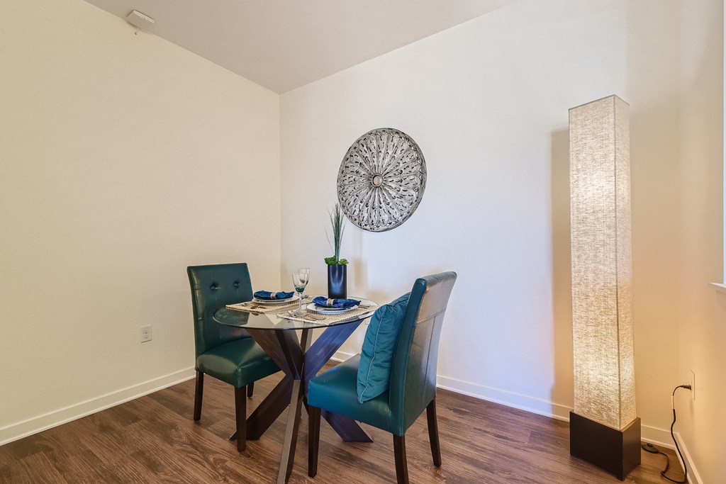 a dining room with a table and chairs and a lamp