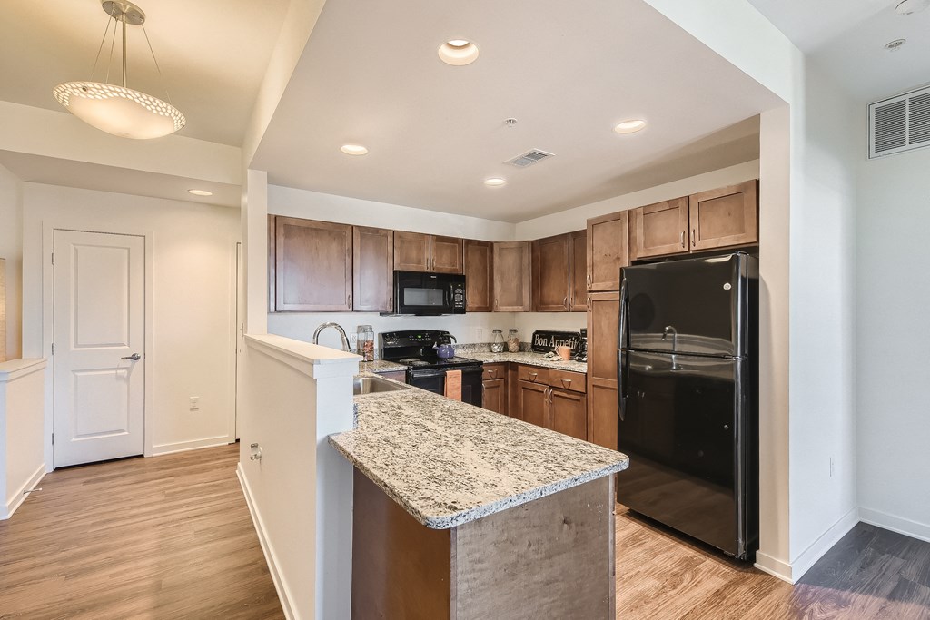 a kitchen with black appliances and granite counter tops
