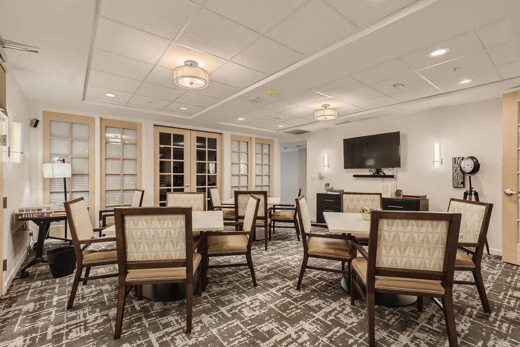 a conference room with tables and chairs and a television