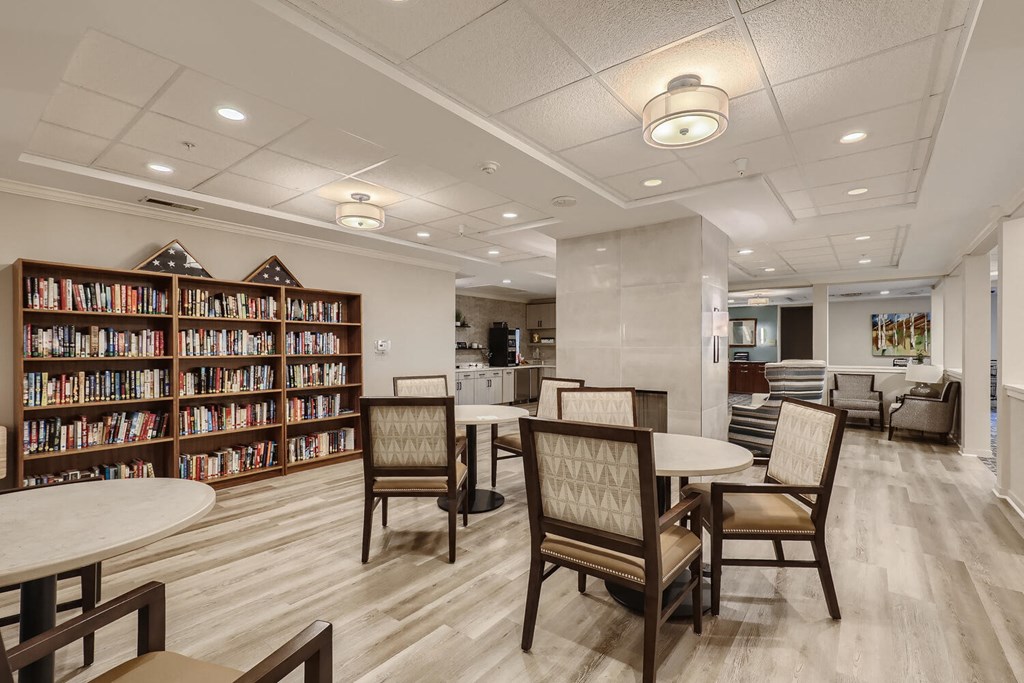 a room with tables and chairs and a library