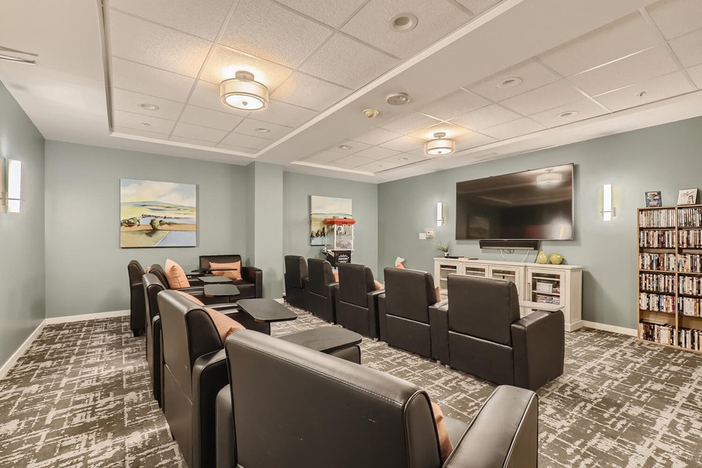 a conference room with a table and chairs and a television