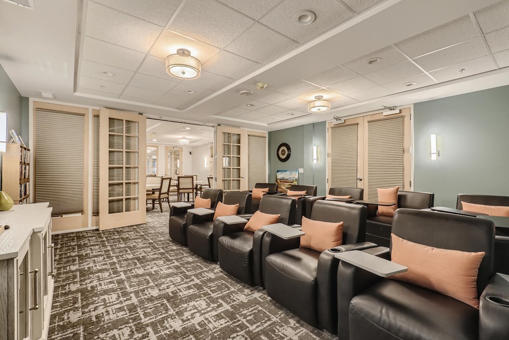 a theater room with leather chairs and blue walls