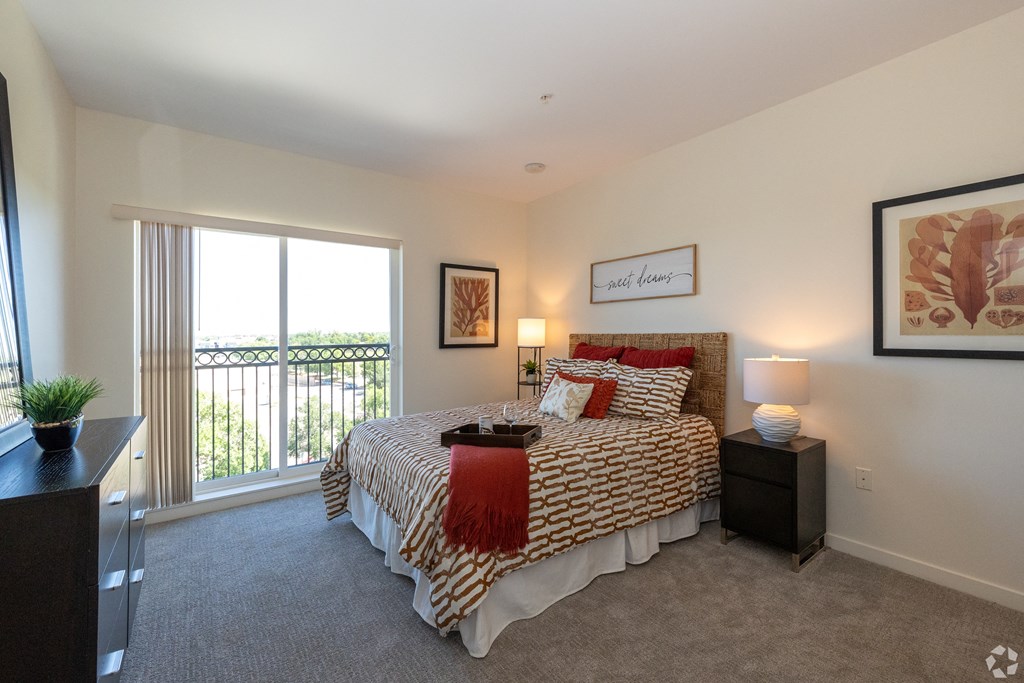 a bedroom with a large bed and a window with juliet balcany