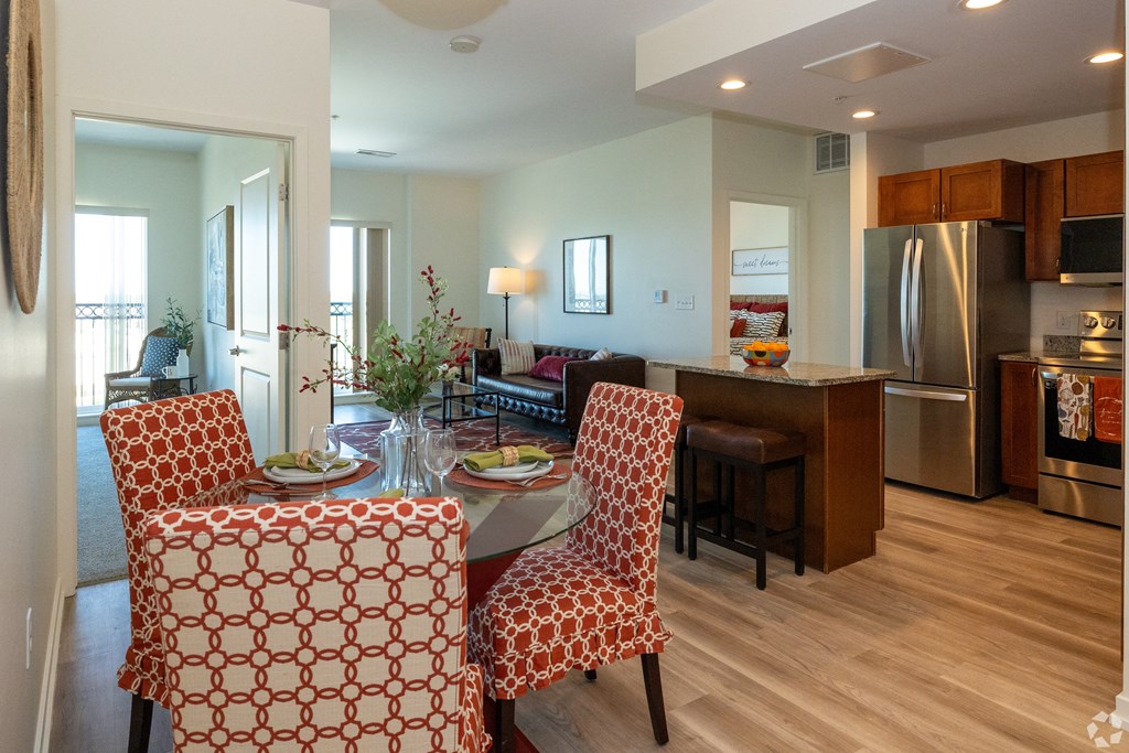 a living room and kitchen with a dining room table and chairs